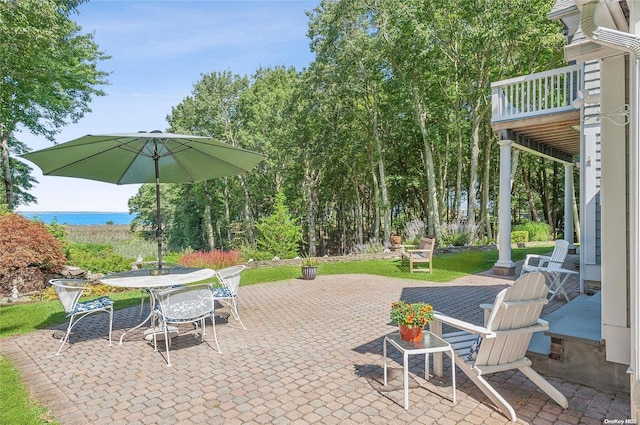 view of patio featuring a balcony and a water view