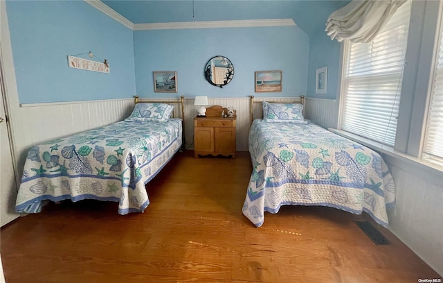 bedroom with hardwood / wood-style floors, multiple windows, ornamental molding, and wood walls