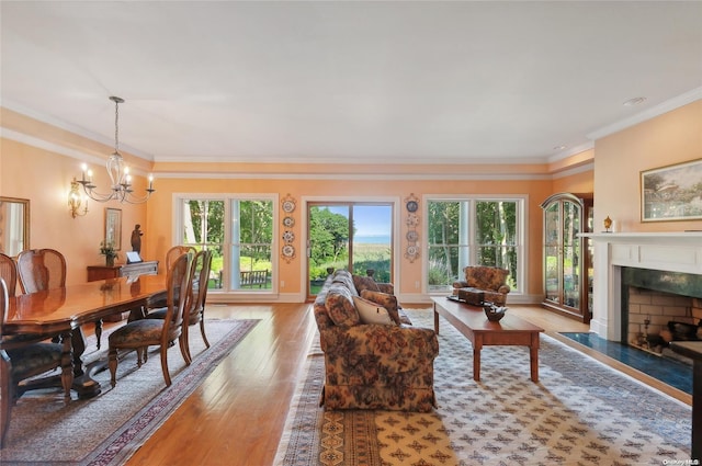 156 Ram Island Dr, Shelter Island, NY 11964 - living area featuring healthy amount of natural light, a chandelier, light wood-type flooring, a fireplace, and crown molding