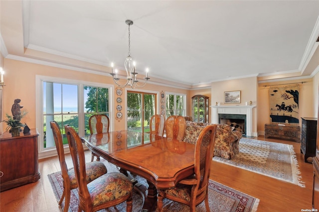 156 Ram Island Dr, Shelter Island, NY 11964 - dining space with a chandelier, wood finished floors, crown molding, and a fireplace