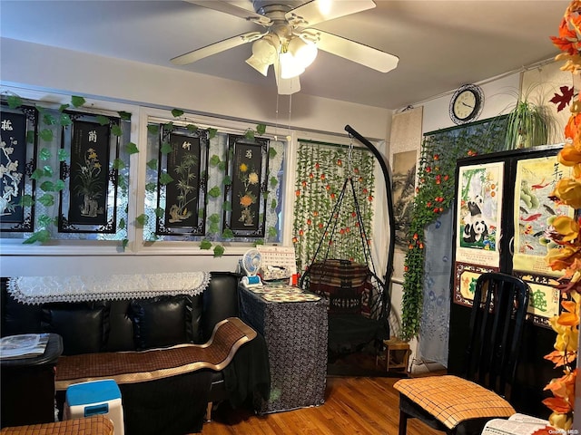 sitting room with hardwood / wood-style floors and ceiling fan