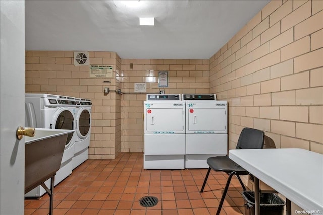 laundry area featuring tile patterned flooring, independent washer and dryer, and tile walls