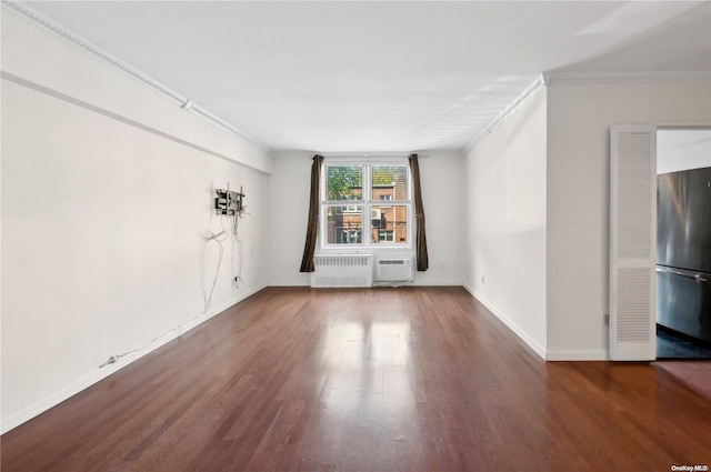 spare room with radiator heating unit, dark hardwood / wood-style floors, and crown molding