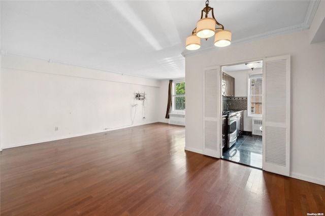 interior space featuring radiator heating unit, dark wood-type flooring, a notable chandelier, and ornamental molding