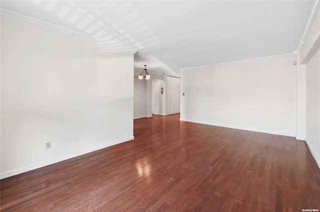 spare room featuring dark hardwood / wood-style flooring and crown molding