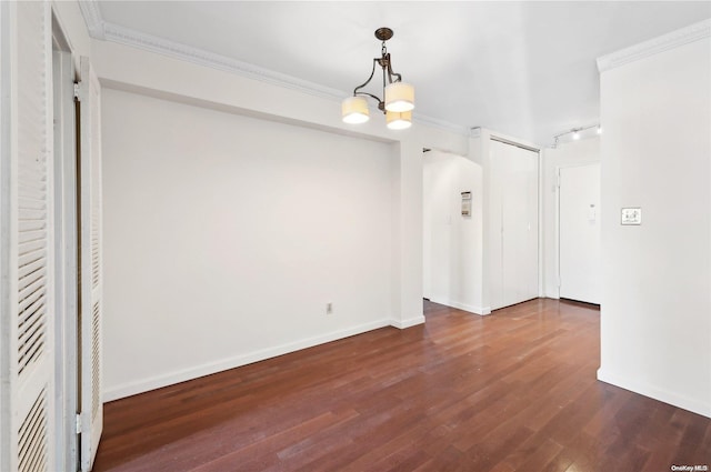 unfurnished dining area with dark hardwood / wood-style flooring, ornamental molding, and a notable chandelier