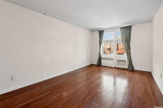 unfurnished room featuring dark hardwood / wood-style flooring, ornamental molding, and radiator