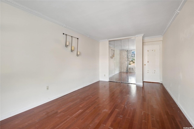 empty room featuring dark hardwood / wood-style flooring and ornamental molding