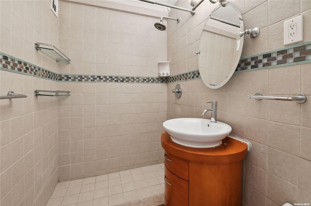 bathroom featuring vanity, tile patterned floors, and tile walls