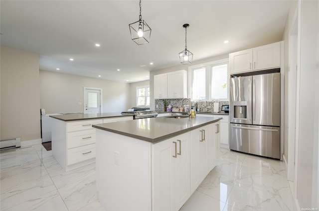 kitchen with sink, a center island, stainless steel refrigerator with ice dispenser, decorative light fixtures, and white cabinets