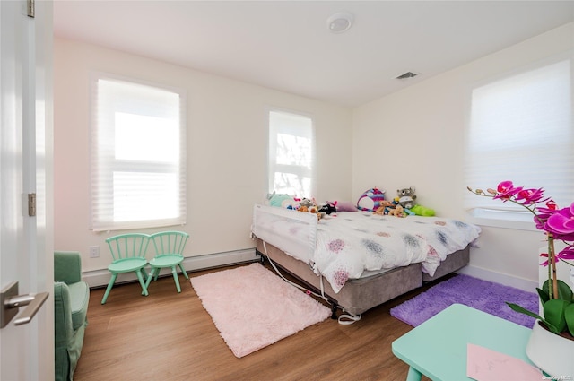 bedroom featuring light hardwood / wood-style floors and a baseboard radiator