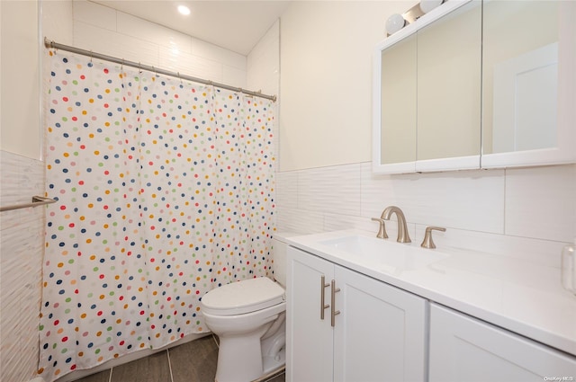 bathroom featuring a shower with curtain, vanity, toilet, and tile walls