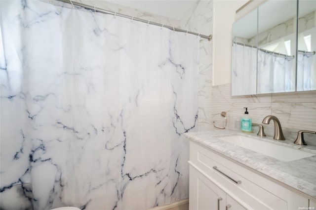 bathroom featuring vanity, tasteful backsplash, and walk in shower