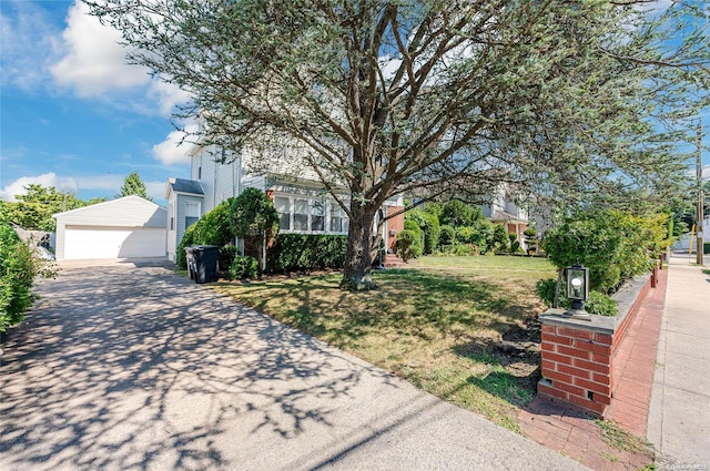 obstructed view of property with an outbuilding, a garage, and a front lawn