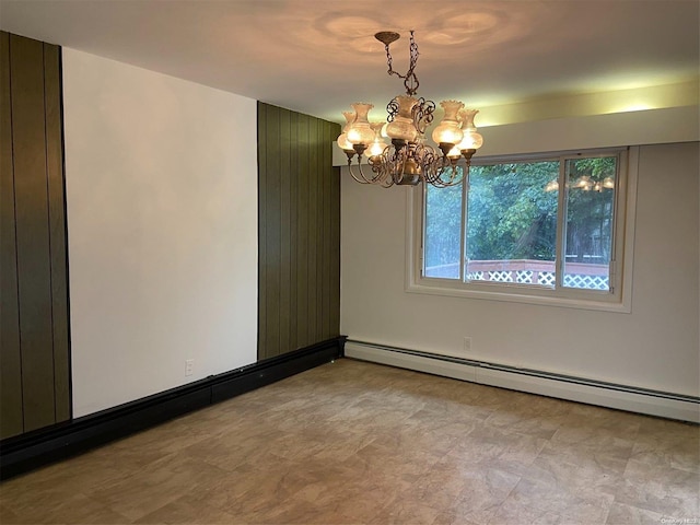 unfurnished room featuring baseboard heating and a chandelier