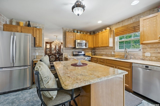 kitchen featuring a breakfast bar, stainless steel appliances, sink, light tile patterned floors, and a kitchen island