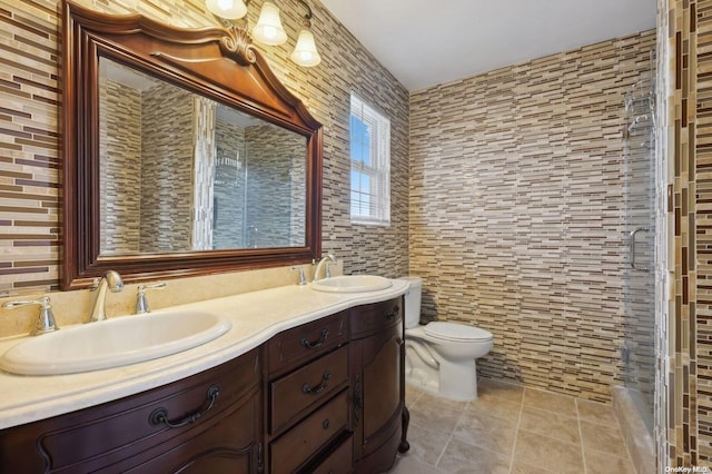 bathroom with tile patterned flooring, vanity, toilet, and tile walls