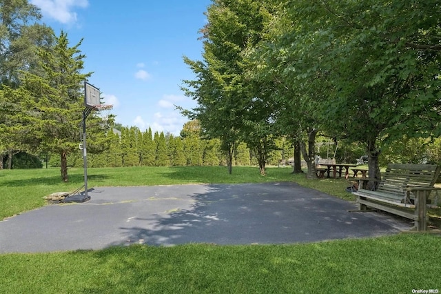 view of sport court with a yard