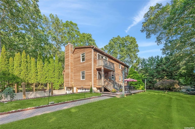 rear view of property with a lawn and a balcony