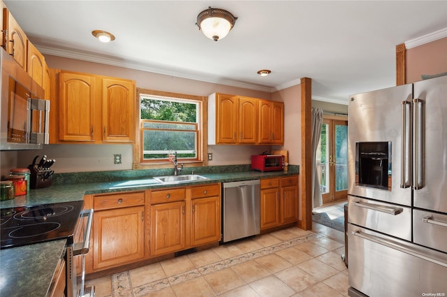 kitchen featuring appliances with stainless steel finishes, light tile patterned floors, crown molding, and sink