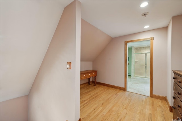 additional living space with light wood-type flooring and lofted ceiling