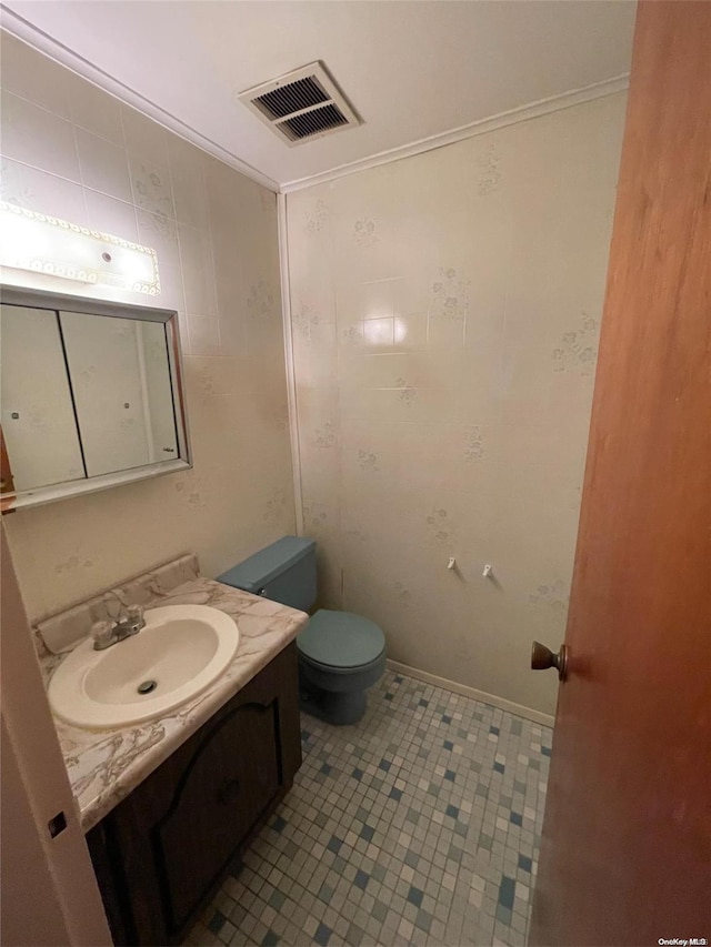 bathroom featuring tile patterned floors, toilet, vanity, and ornamental molding