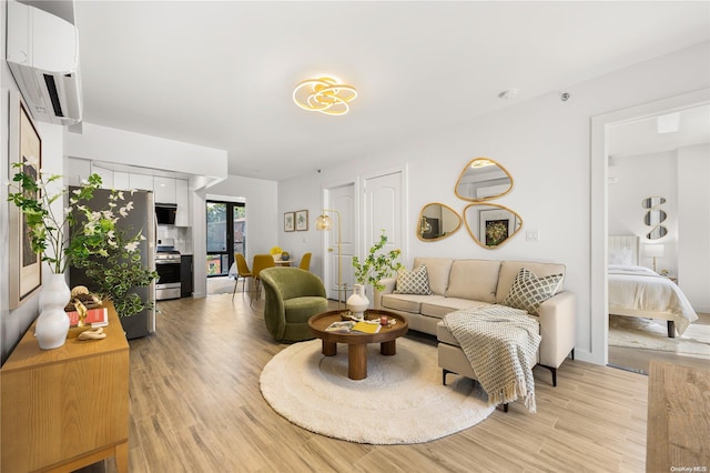 living room with light wood-type flooring and a wall mounted AC