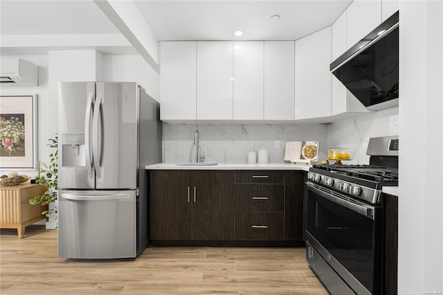 kitchen featuring white cabinets, sink, appliances with stainless steel finishes, dark brown cabinets, and light hardwood / wood-style floors