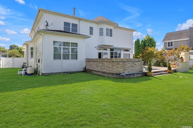 rear view of house featuring a lawn