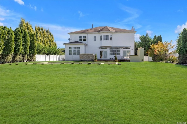 rear view of property featuring a lawn