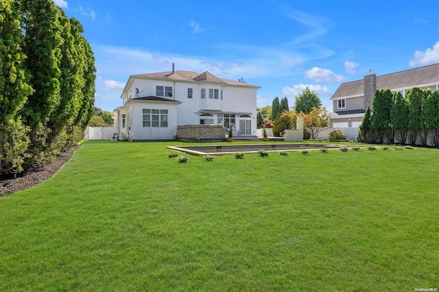 rear view of property with a yard