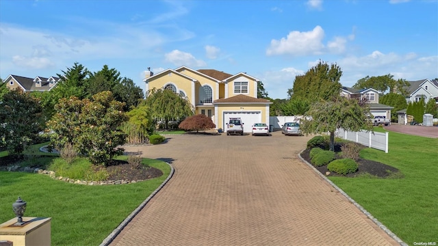 view of front of home with a front lawn and a garage