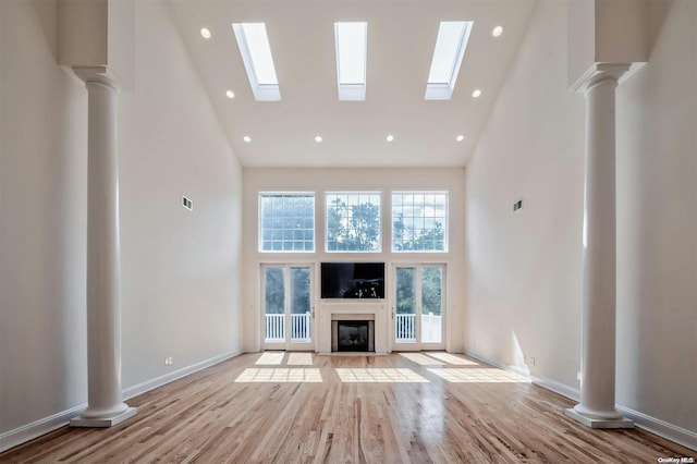 unfurnished living room with high vaulted ceiling and light hardwood / wood-style flooring