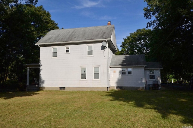 rear view of house featuring a yard