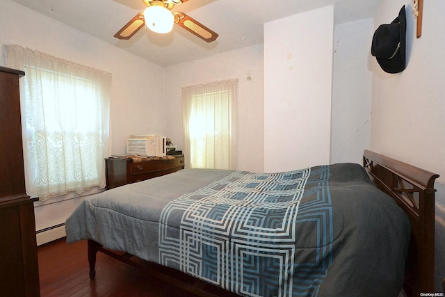 bedroom featuring multiple windows, ceiling fan, dark hardwood / wood-style flooring, and a baseboard radiator