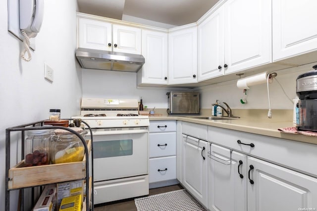 kitchen featuring white range oven, sink, white cabinets, and dark tile patterned flooring