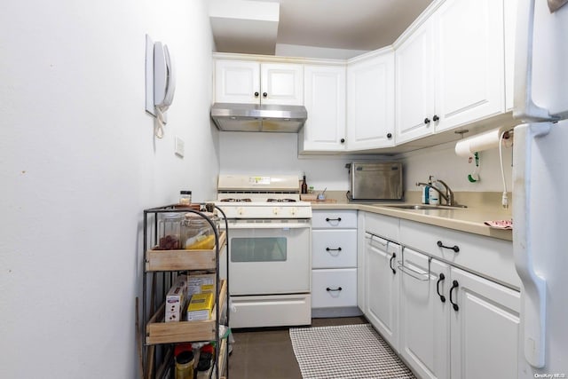 kitchen with white cabinets, dark tile patterned floors, white appliances, and sink