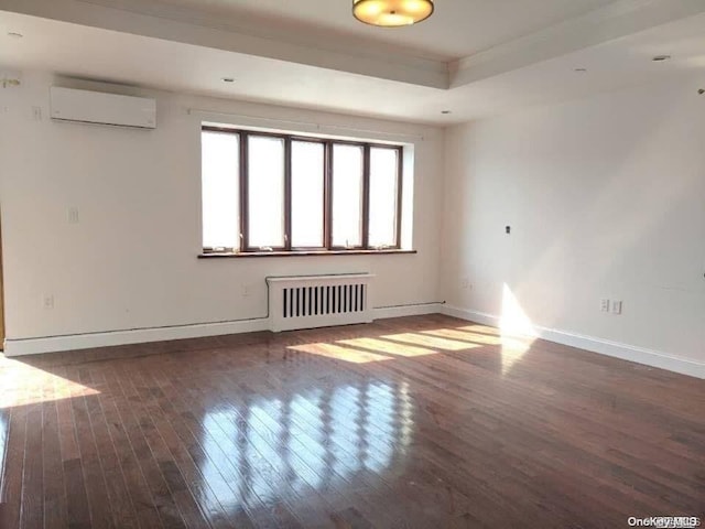 empty room with an AC wall unit, radiator heating unit, and dark wood-type flooring