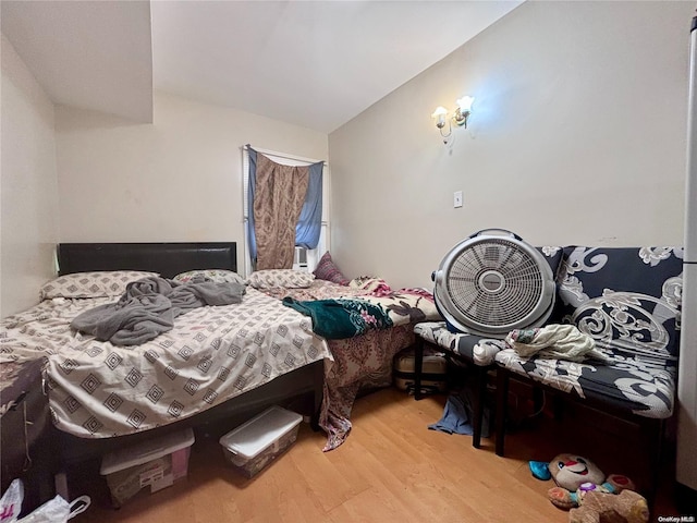 bedroom featuring lofted ceiling and light wood-type flooring