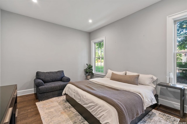 bedroom featuring dark hardwood / wood-style floors and multiple windows