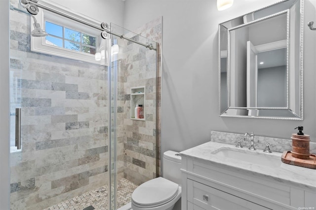 bathroom featuring vanity, toilet, and a shower with shower door