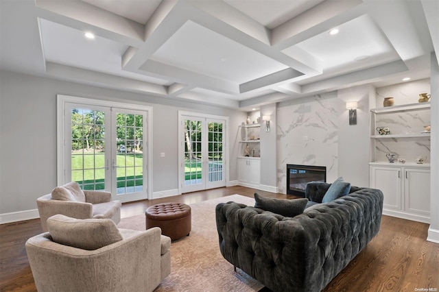 living room featuring french doors, a fireplace, dark wood-type flooring, and coffered ceiling