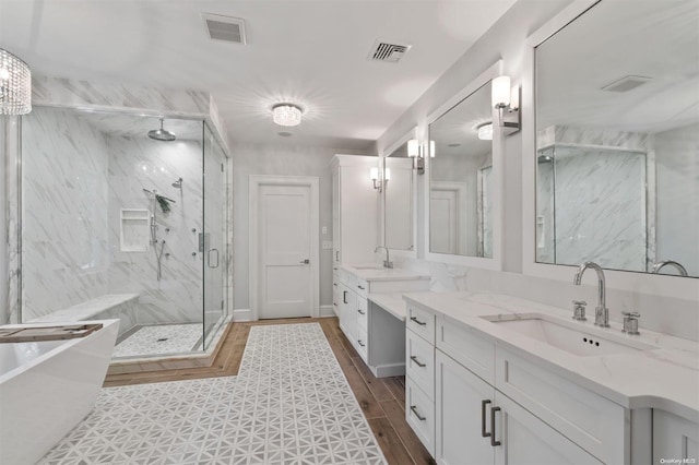 bathroom with walk in shower, vanity, and hardwood / wood-style flooring