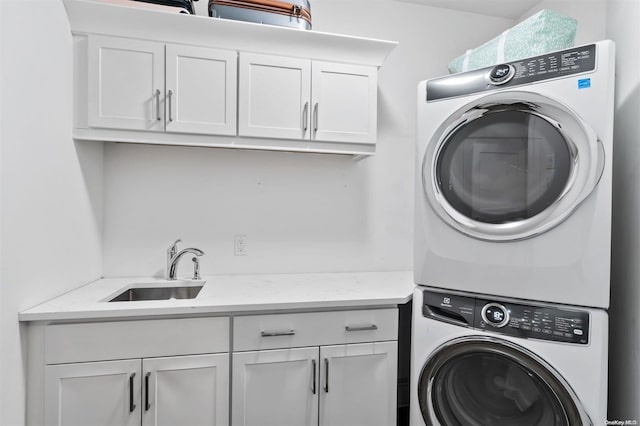 clothes washing area featuring sink, cabinets, and stacked washer / drying machine