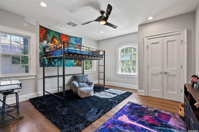 bedroom with hardwood / wood-style floors, a closet, and ceiling fan