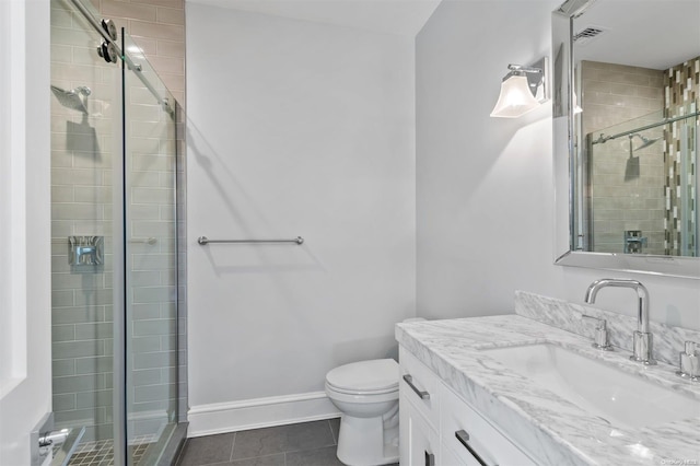 bathroom with tile patterned floors, vanity, toilet, and a shower with door