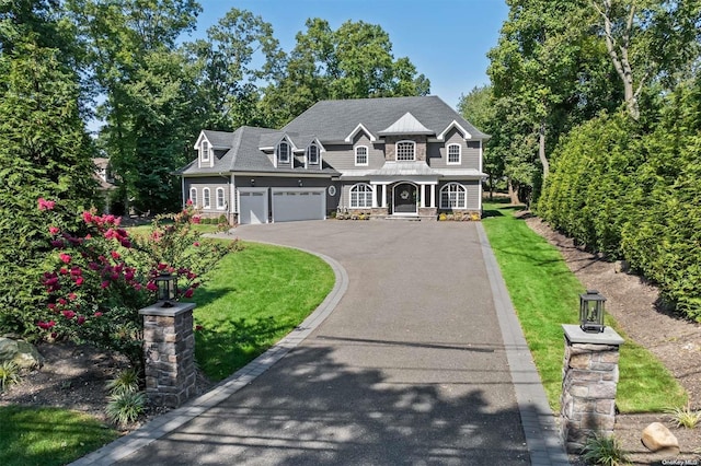 view of front of property with a porch, a garage, and a front lawn