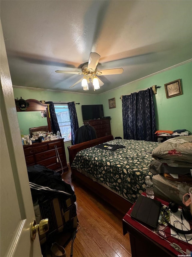 bedroom with ceiling fan, wood-type flooring, and crown molding