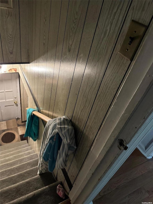 stairway with wood walls and wood-type flooring