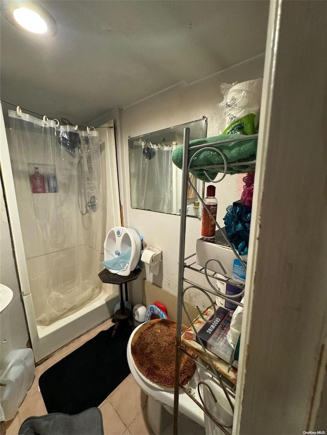 bathroom with a shower with curtain, tile patterned flooring, and toilet